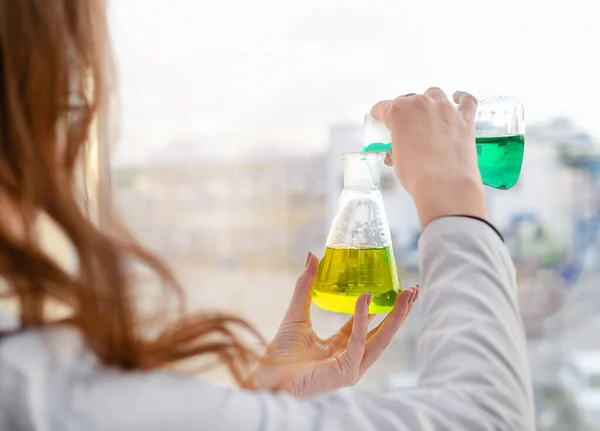 Een meisje laboratorium assistent mengt reagentia in een chemisch laboratorium — Stockfoto