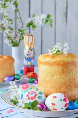 Mutlu Paskalya kavramı. Tatlı ekmek yemiş/kuru meyveler ve renkli yumurta ile. Tatil kahvaltı. Ortodoks kulich. Festival tablo yer dekorasyon paska, çiçeği twigs, bunny, çikolata yumurta ile.