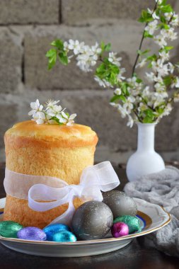 Mutlu Paskalya kavramı. Tatlı ekmek yemiş/kuru meyveler ve renkli yumurta ile. Tatil kahvaltı. Ortodoks kulich. Festival tablo yer dekorasyon paska, çiçeği twigs, bunny, çikolata yumurta ile.