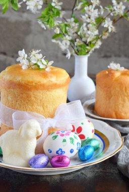 Mutlu Paskalya kavramı. Tatlı ekmek yemiş/kuru meyveler ve renkli yumurta ile. Tatil kahvaltı. Ortodoks kulich. Festival tablo yer dekorasyon paska, çiçeği twigs, bunny, çikolata yumurta ile.