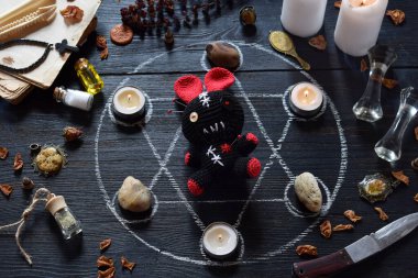 Voodoo tavşan iğneler dikilmiş vardır. Mumlar, pentagram, taşlar, aşk iksiri ve cadı masasında eski kitaplar. Gizli, ezoterik veya kehanet kavramı. Mistik, Cadılar Bayramı ve vintage arka plan
