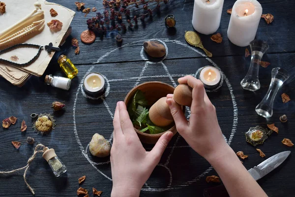 Kadın elleri mumlar, taşlar ve cadı masasında eski kitaplar ile pentagram daire üzerinde aşk iksiri yapmak. Gizli, ezoterik veya kehanet kavramı. Mistik, Cadılar Bayramı ve vintage arka plan