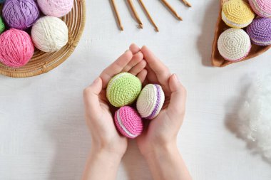 Making crochet amigurumi french macarons. Toy for babies or trinket.  Threads, needles, hook, cotton yarn. Handmade gift. Income from hobby. DIY crafts concept.