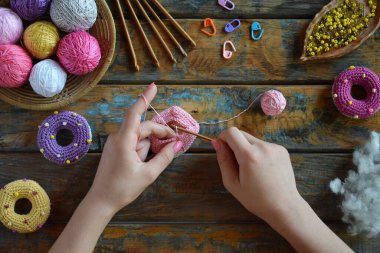 Making crochet amigurumi donuts. Toy for babies or trinket.  On the table threads, needles, hook, cotton yarn. Handmade gift. Income from hobby. DIY crafts concept. Step 1 - knit all details.