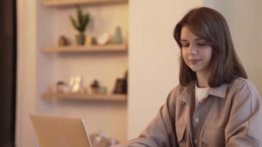 Evde çalışan serbest çalışan bir kadın sosyal ağda dizüstü bilgisayar kullanıyor.