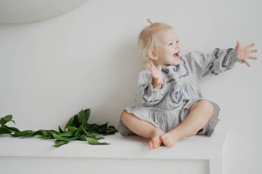 Evde oynayan küçük sarışın kız ellerini çırpıyor. t aranıyor