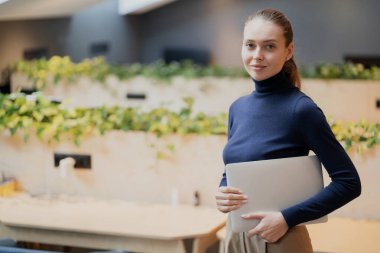 Önemli notlar içeren bir dizüstü bilgisayar tutuyordu. Kendine güven güçlü