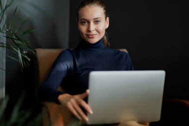 Kameraya bakarken, kendine güvenen genç bir kadın...