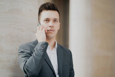 Elinde yeni bir telefon görüşmesi tutan bir iş adamının portresi.