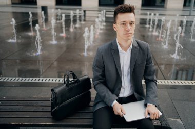 Ciddi bir öğretmen, Avrupa görünümlü, zeki bir adamdır.