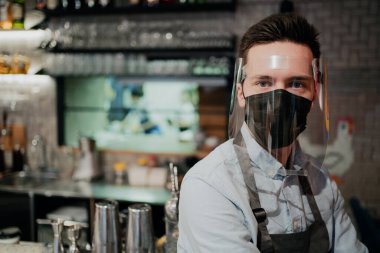 Lokantada çalışan garson koruyucu bir maske takıyor.