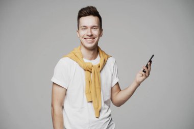 Mutlu adam telefondaki mesajları okur, kameraya bakar.