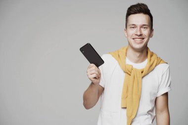 Elinde yeni bir telefon tutan mutlu genç bir öğrenci. Memnun oldum.