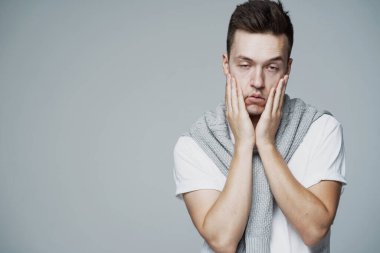 Çalışmaktan bıkmış eller Avrupalı genç bir adamın yüzüne dokunuyor.