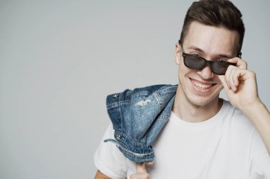 Kafkas görünümlü, güneş gözlüklü, şık bir genç adam.