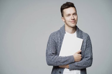 Akıllı, ciddi bir öğrenci iki elinde bir kitap tutuyor, beyaz kol.