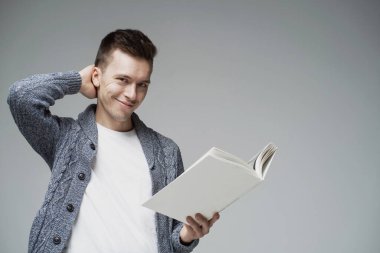 Öğrenci kapağın beyaz renginde ilginç bir kitap okuyor., 