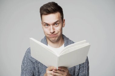 Avrupa görünümlü zeki bir genç adam, ilginç bir kitap okuyor.