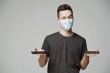 Kafkas ırkından oyuncu bir adam, elinde iki telefon gösteriyor.. 