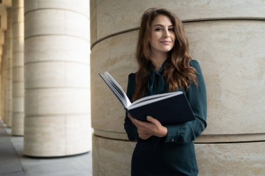 Enstitü 'deki öğretmen koçunun elinde belgeleri var.