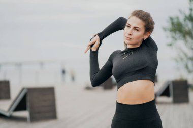 Genç bir atlet esneme egzersizi yapıyor. Siyah bir jakuzi.