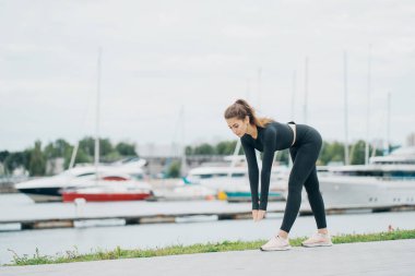 İleri eğilme egzersizleri yapar aerobik sağlıklı yaşam tarzı. styli