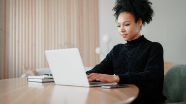 Tatmin olmuş serbest çalışan bir öğrenci bir dizüstü bilgisayardaki mesajı okur.