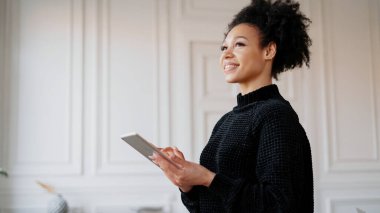 Bir bayan öğrenci internette çalışırken gülümsüyor.