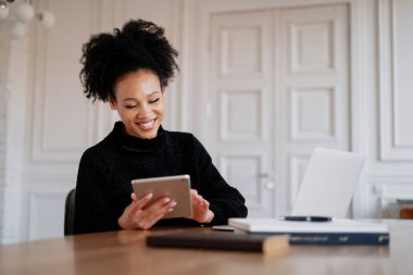 Tatmin olmuş serbest çalışan bir öğrenci bir dizüstü bilgisayardan bir mesaj okuyor.