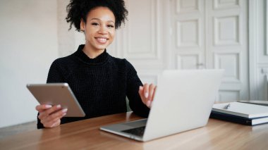 Tatmin olmuş serbest çalışan bir öğrenci bir dizüstü bilgisayardan bir mesaj okuyor.