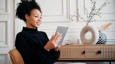 Tasarımcı kız afro görüntüsü. Evde internet üzerinde çalışıyor anne.