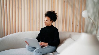 Tasarımcı kadın afro görünüş. Evde internet üzerinden çalışınca daha iyi oluyor.
