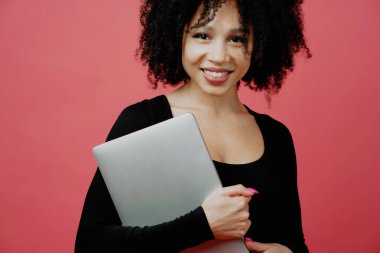 Bir öğrenci elinde bir dizüstü bilgisayar tutuyor. Pozitif ruh hali. Genç bayan.