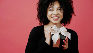 Elinde fiyonk olan siyah bir hediye kutusu. Genç wo