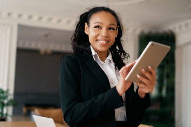 Finansör, bir iş arkadaşına e-posta mesajı basıyor. İş kadını afro gülümseme yöneticisi dizüstü bilgisayar ve tablet üzerinde çalışıyor. Avukat modern bir kiralık ofiste oturuyor..