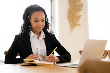 Birlikte çalışma konusunda çevrimiçi video eğitimi. Yönetici Afro görünüş ofiste en sevdiği iş. Mutlu yönetici danışman kadın müşteriye mektupları cevaplıyor..