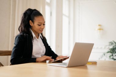 Müşteriye bir e- posta iletisi yazdırır. Kadın yönetici evde tablet üzerinde çalışırken gülümsüyor. Muhasebeci çevrimiçi tablodaki krediyi hesaplar. Video bağlantısı üzerinden çevrimiçi uzaklık öğrenme.