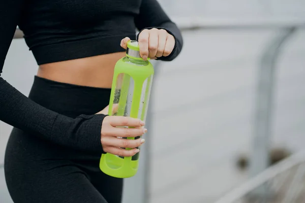 design sports pure water bottle in the hands of a woman, quenche