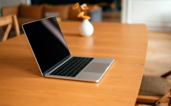 Laptop masaüstünde açık, ekran uyku modunda kapalı.