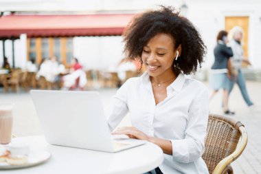 Menajer çevrimiçi iş yapıyor. Yazlık bir kafede dizüstü bilgisayarda çalışan serbest çalışan bir kadın. Blogcu sohbetteki müşterilere yanıt verir.