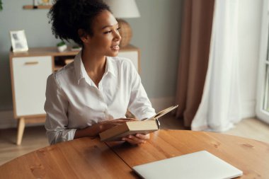 Favori roman bir edebiyat eseridir. Güzel bir kadın kitap okuyor ve gülümsüyor. Konforlu bir ev zamanı. Akıllı bir insan bilgi alır..