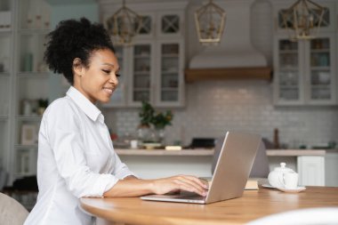 Evdeki ve cihazdaki işyeri. Freelancer ara verdiğinde internette sörf yapıyor. Evde, bilgisayarın başında dinleniyor. Sosyal ağlardaki arkadaşlarına cevap veriyor. Beyaz gömlekli bir kadın çalışıyor..