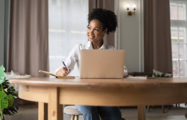 Kadın çevrimiçi eğitimi. Evdeki ve cihazdaki işyeri. Freelancer ara verdiğinde internette sörf yapıyor. Evde, bilgisayarın başında dinleniyor. Sosyal ağlardaki arkadaşlara yanıtlar.