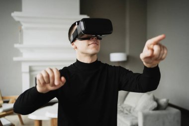 Bir programcı evde sanal gerçeklik oyunu oynar. VR koymuş.