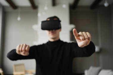 Kafama sanal gerçeklik kaskı taktım. Siyah ceketli bir adam ders çalışıyor.