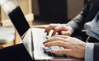Bilgisayarı açar ve şifreyi yazdırır. Bir erkek finansör