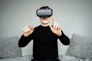 Kafasında sanal gerçeklik kaskıyla kanepede oturuyordu. Bir adam...