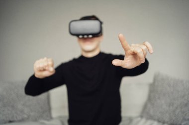 Kafama sanal gerçeklik kaskı taktım. Siyah ceketli bir adam ders çalışıyor.