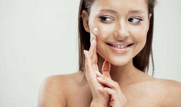 beautiful face, woman applies anti-aging cream cosmetics profess