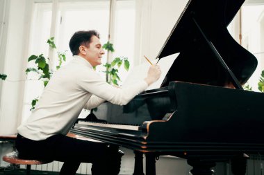 Erkek sanatçı, müzik okulunda 50-60 yaşlarında bir öğretmen. Evde piyano çalıyor. Güzel klasik müzik, güzel akustik..